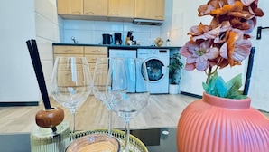 Een keuken met houten kastjes, een koffiezetapparaat en een wasmachine.