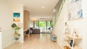 Una sala de estar moderna con un sofá, una mesa de centro y un muro de cristal.