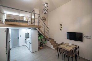 A modern apartment with a kitchen, dining area, and a staircase leading to a loft bedroom. - Loft 53 – Twin Loft II by ΜΡS (Athens)