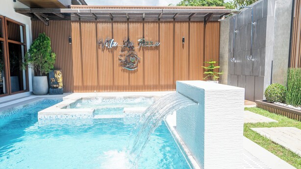 Une piscine avec un mur en bois et une pancarte indiquant « Villa La Pizza ».