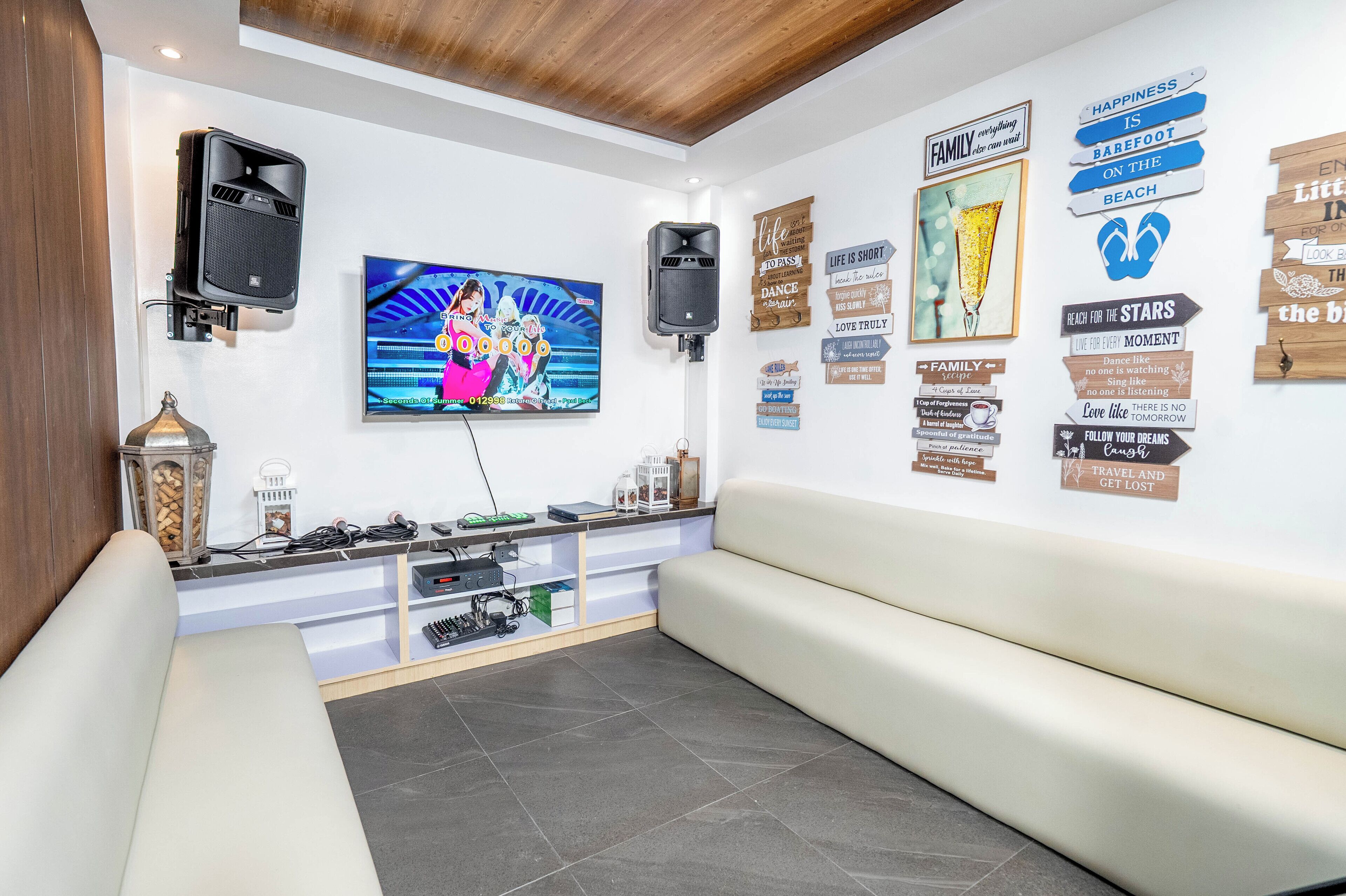 Un moderno vestíbulo de hotel con un televisor de pantalla plana, parlantes integrados en la pared, una zona de estar y decoración mural inspiradora.
