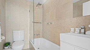 Une salle de bain moderne équipée de toilettes, d’une douche et d’une baignoire.