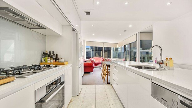 A modern kitchen with white cabinetry, a built-in stove, and a large window. - Canberra Lakefront 2-Bed with Pool, (Kingston)