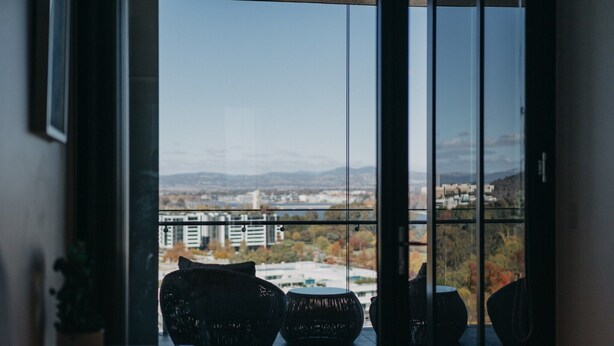 Ein Balkon mit Korbmöbeln und Blick auf die Stadt.