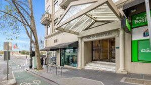 A building with a glass entrance, a sign for 'ONE EXHIBITION', and a bike lane. - Chic 1-Bed Apartment In the Heart of Melbourne (Melbourne)