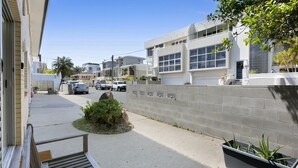 A residential street with modern houses, a sidewalk, and parked cars. - Ground Floor 2-Bed Mermaid Beach Pad with Parking (Mermaid Beach)