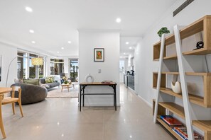 Ein modernes Wohnzimmer mit einer Couch, einem Couchtisch und einem Bücherregal.