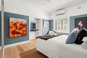 A bedroom with a large bed, a window with blinds, a painting on the wall, and a door leading to another room. - Superb 2-Bed Apartment Facing Rose Bay Marina (Rose Bay)