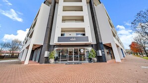A modern building with a flat facade, large windows, and a prominent entrance.