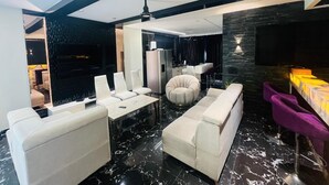 A modern living room with a sofa, armchairs, a coffee table, and a TV. - THE PAD BY FRACSPACE (Hyderabad)