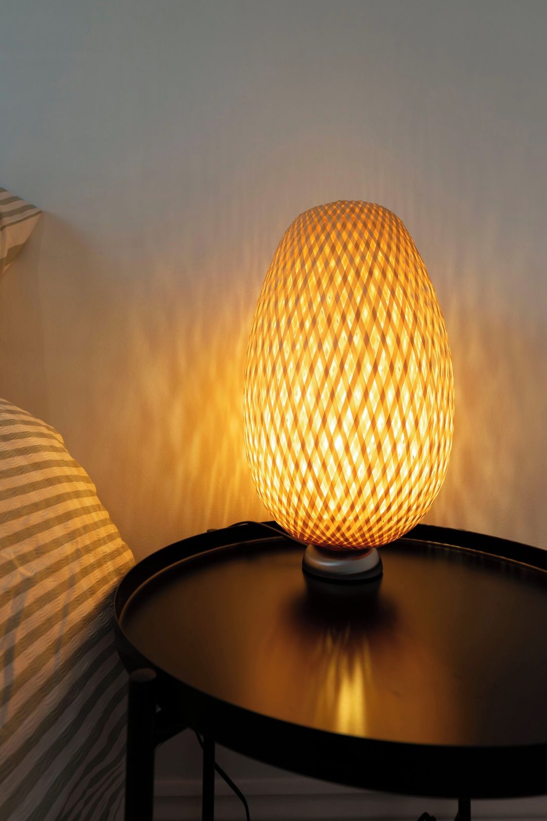 A spherical lamp with a textured surface on a round table.