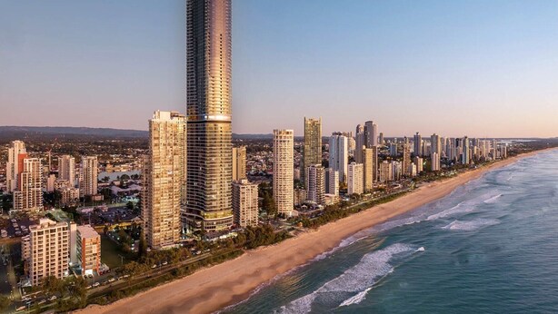 Paisatge urbà costaner amb edificis alts, una platja i un cel serè.