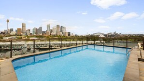 Una piscina amb un paisatge urbà al fons.