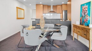 Une cuisine moderne avec des meubles en bois, un réfrigérateur en acier inoxydable et un four encastré.