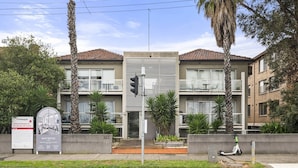 Un immeuble d’appartements moderne doté d’un balcon, d’une enseigne et d’une piste cyclable aménagée.