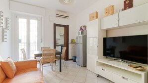 Een moderne woonkamer met een bank, tv en kasten.