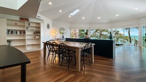 Uma cozinha moderna com área de jantar, piso de madeira e vista para o exterior.