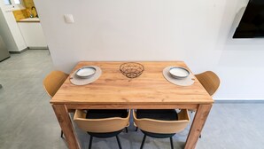 Ein Holztisch mit zwei Stühlen, einem geometrischen Mittelstück und zwei darauf stehenden Tellern.