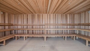 Ein Saunaraum mit Holzbänken und schmalen Holzwänden.