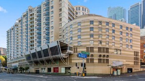 Ein hoch aufragendes Hotel mit modernem Design, das mehrere Balkone und eine geschwungene Fassade aufweist.