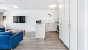 A modern apartment with a living room, kitchen, and a large wardrobe. - Resort-Style Stay with Balcony & Garage Parking (Torquay)