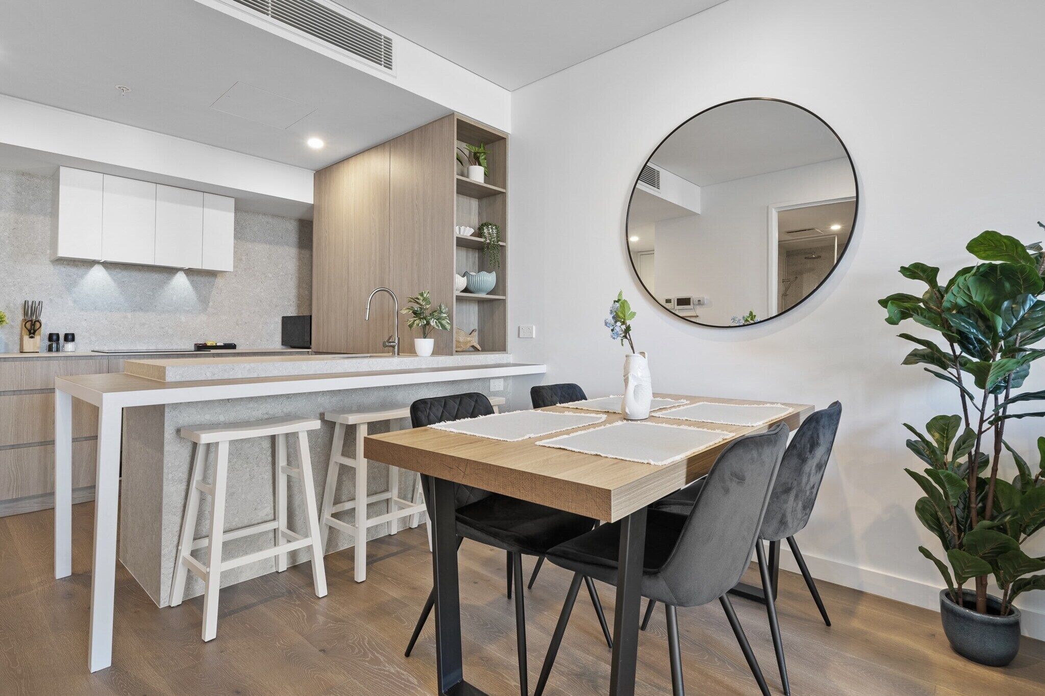 Une cuisine moderne dotée d’un îlot central, de tabourets de bar et d’une table à manger avec des chaises.
