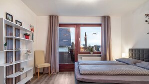 Une chambre à coucher avec un lit, une chaise, une bibliothèque et une fenêtre avec des rideaux.