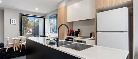 Una cucina moderna con isola centrale, elettrodomestici in acciaio inossidabile e mobili in legno.