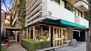 Un edificio moderno con un restaurante llamado 'Harper's Kitchen' en la planta baja.