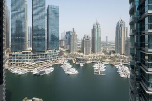 A marina with numerous boats docked, surrounded by high-rise buildings with modern architecture. - Experience 2BR Luxury Living  LIV Marina (Dubai)