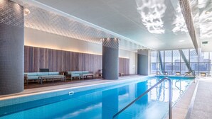 A modern indoor swimming pool with a clear view of the city skyline through large windows. - Elegant Southbank Escape Apartment with Balcony (Southbank)