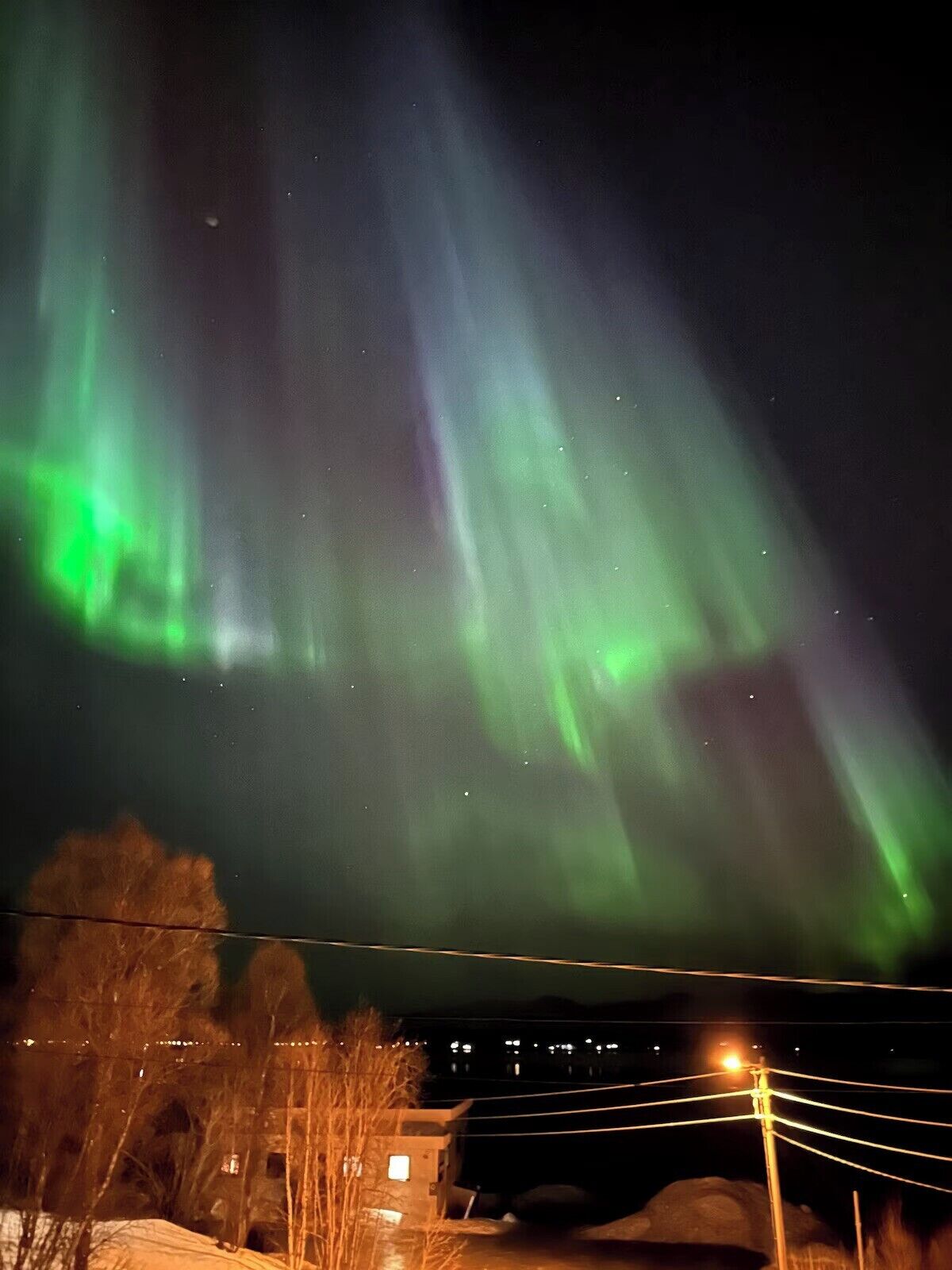 A night view of the Northern Lights with visible aurora borealis.