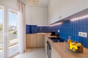 A modern kitchen with a wooden countertop, a sink, and a blue tiled backsplash. - Aegean Blue Hideaway w/ Fireplace, near Acropolis (Athens)