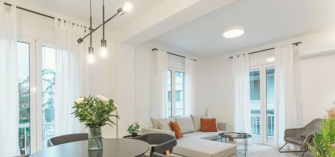 Una sala de estar moderna con una mesa de comedor, sofá y sillas.