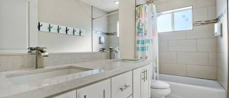 Un baño con un lavabo grande, espejo, inodoro y bañera.
