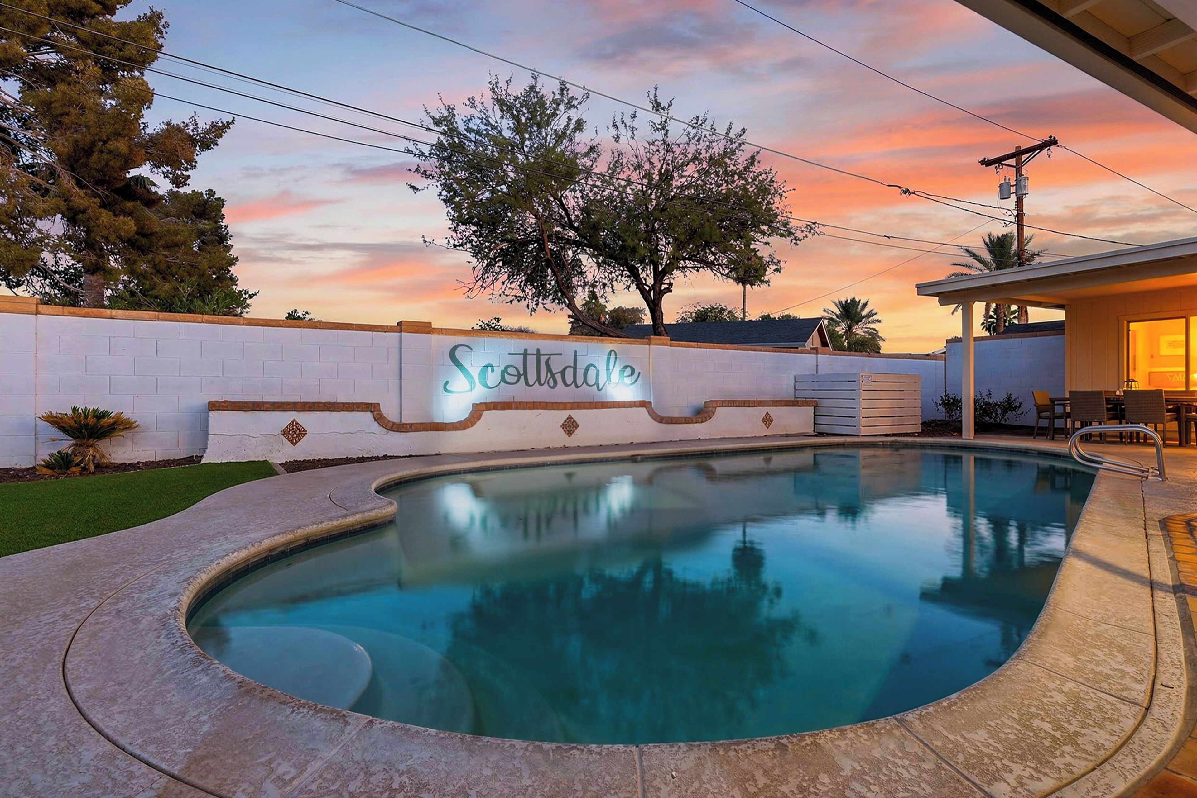 Une piscine avec un panneau indiquant « Scottsdale » et un coucher de soleil en arrière-plan.