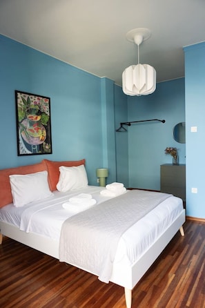 A bedroom with a bed, a painting, a bedside lamp, a dresser, and a mirror. - Vibrant Retreat Funky Style & Acropolis View! (Athina)
