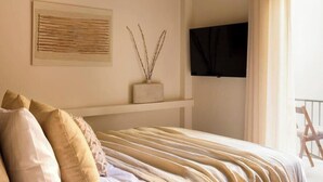 A bedroom with a bed, a mounted TV, a window with curtains, and a wall-mounted shelf with a decorative item. - Luxurious Zen Retreat W/Balcony & 300mbps WiFi (Athina)