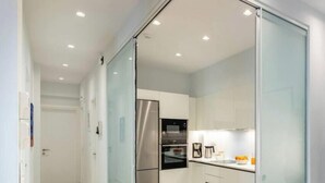 A modern kitchen with a stainless steel refrigerator, a built-in oven, and a coffee maker on the counter. - Upscale central APT, Patio near Hospitals & Metro (Μενεμένη)