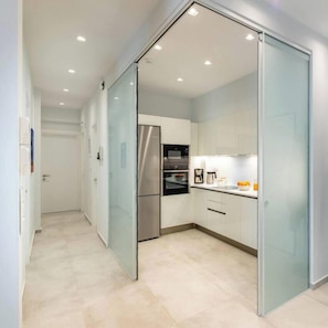 A modern kitchen with a stainless steel refrigerator, a built-in oven, and a coffee maker on the counter. - Upscale central APT, Patio near Hospitals & Metro (Μενεμένη)