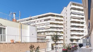 A multi-story residential building with balconies, a clear sky, and some potted plants. - Upscale central APT, Patio near Hospitals & Metro (Μενεμένη)
