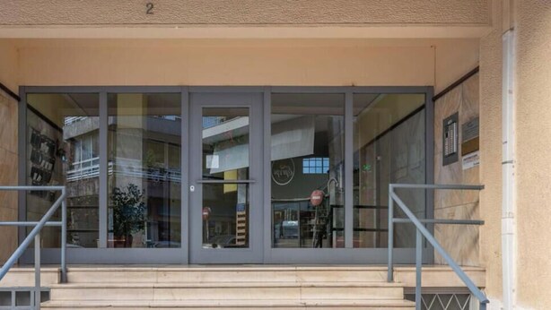A building entrance with a glass door and a metal staircase. - Upscale central APT, Patio near Hospitals & Metro (Μενεμένη)