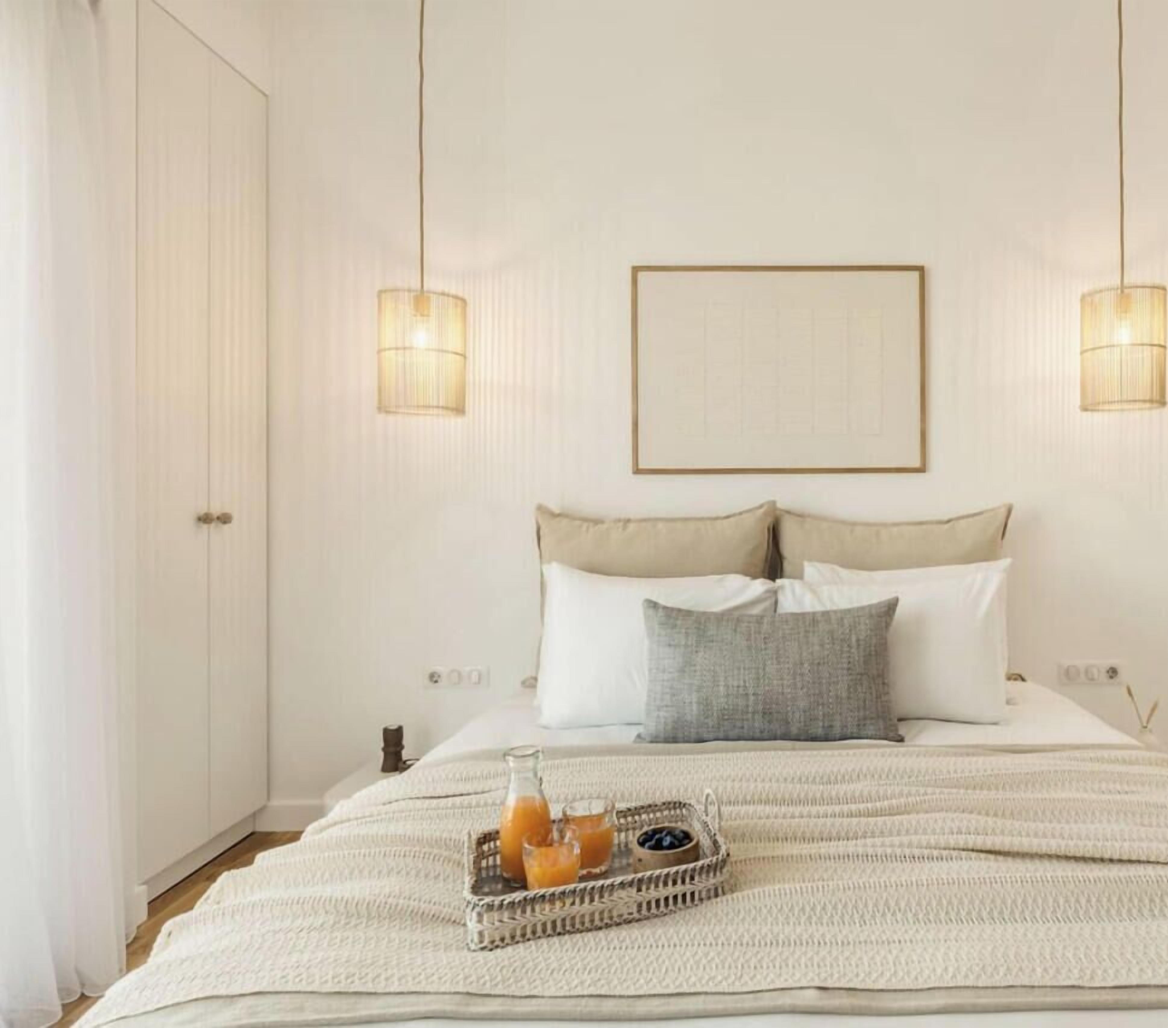 A neatly arranged bedroom with a bed, bedside tables, and a bedside lamp.