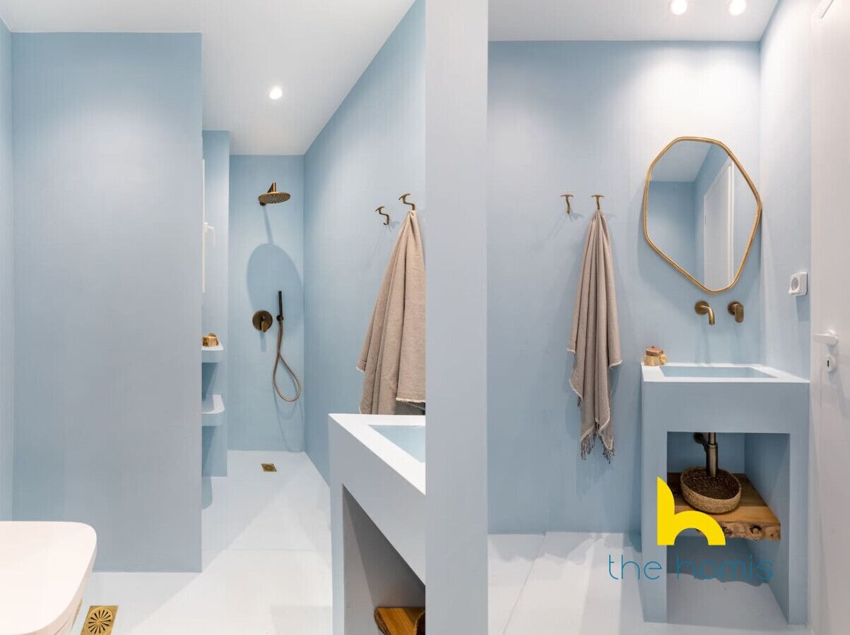 Une salle de bain moderne avec un lavabo blanc, un miroir et une douche.