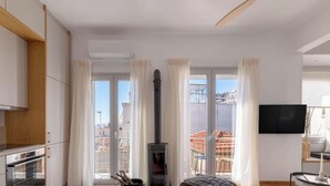 Una cucina moderna con forno a incasso, piano cottura e TV a schermo piatto montata a parete.