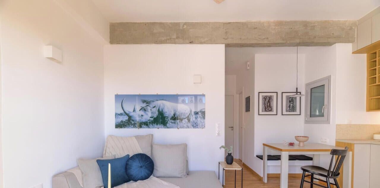 Un salon moderne comprenant un canapé, une table à manger et un coin cuisine.