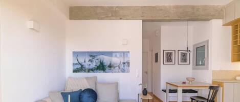 Una sala de estar moderna con un sofá, una mesa de comedor y una zona de cocina.