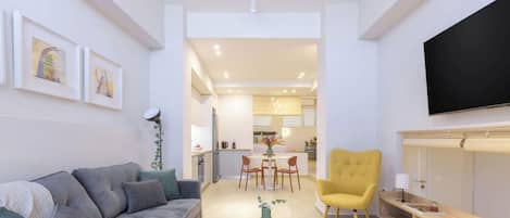 Una sala de estar moderna con un sofá, un sillón amarillo y un comedor con mesa y sillas.