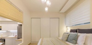 A bedroom with a bed, bedside table, and a wardrobe. - Cozy Hub - Work, Relax, Explore - Prime Location (Athina)