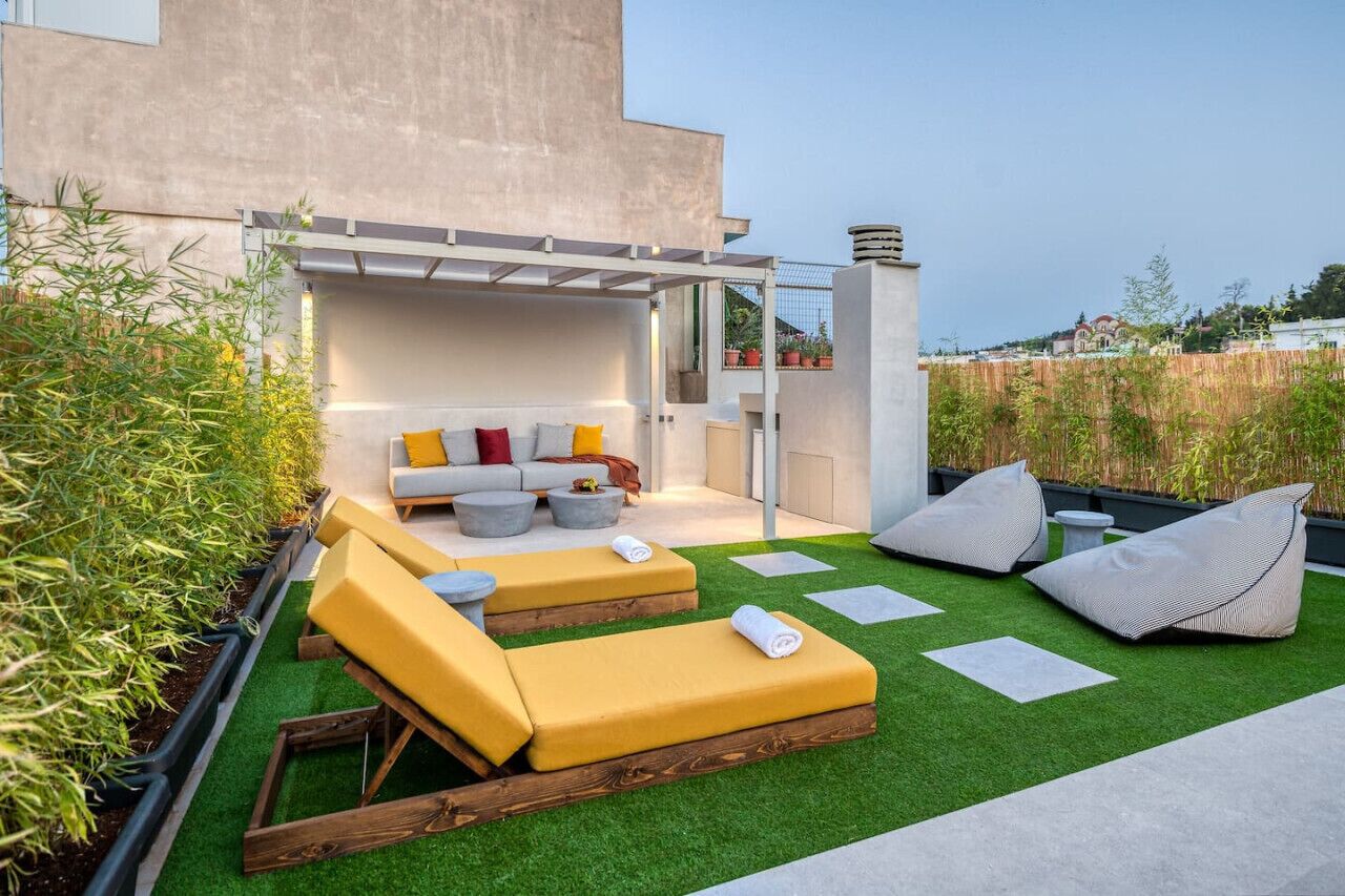Une terrasse sur le toit aménagée avec un ensemble de canapés, des coussins et des fauteuils en forme de poire.